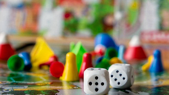 concept of board games. Dice, chips and cards on a green background copy space