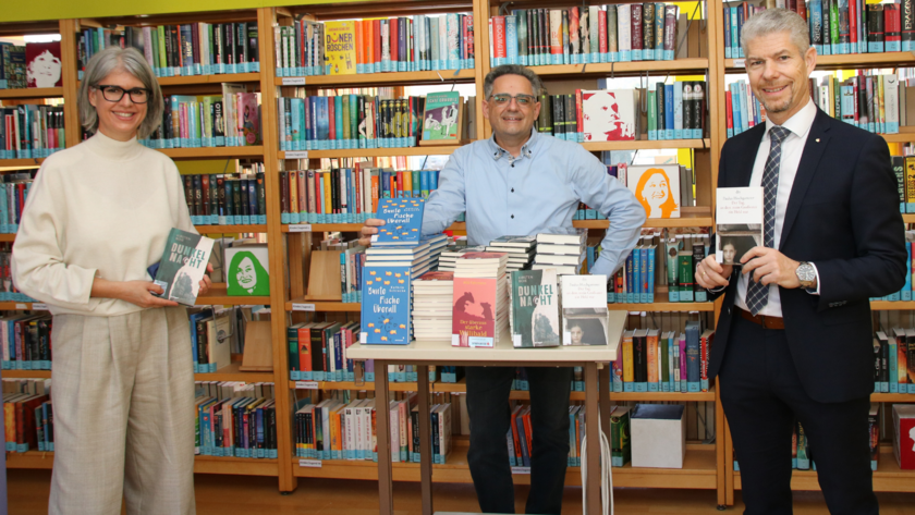 Vlnr: Angelika Kaufmann (mit Jürgen Schacherl für die Bibliothek des Gymnasiums verantwortlich) mit Gerald Fenkart und Thomas Schreiber anlässlich der Übergabe der Bücher in der Bibliothek des Gym-nasiums in Bludenz.